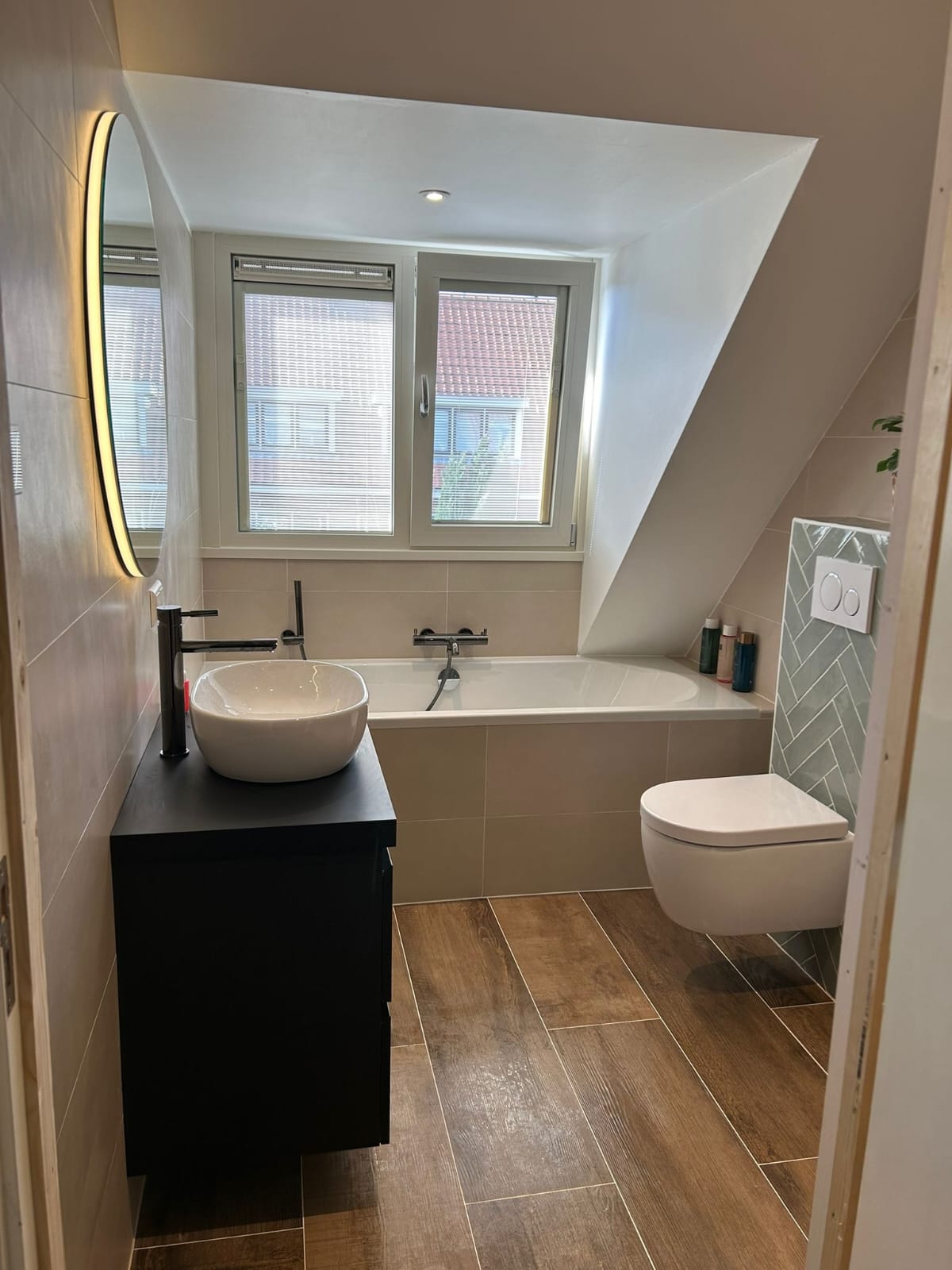 Baño abuhardillado reformado con bañera, lavabo e iluminación LED
