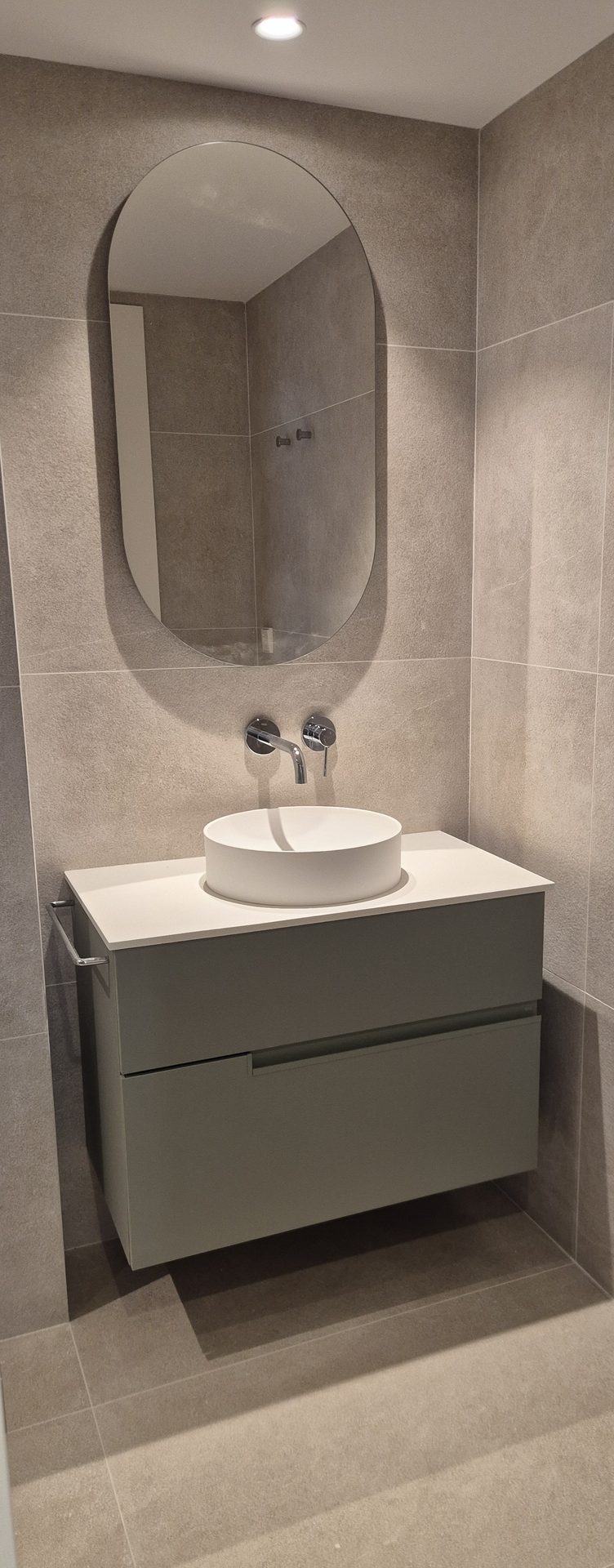 Mueble de baño moderno con lavabo redondo y espejo ovalado